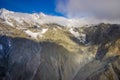 Beautiful landscape of the New Zealand - hills covered by green grass with mighty mountains covered by snow behind