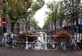 Beautiful landscape of old town Delft with flowers, canal and bikes.