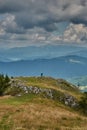 Young man taking pictures of the surrounding view. Scenic summer landscape of the mountains from above.