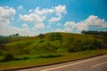 Beautiful landscape overlooking fields and hills with white clouds and blue sky. Brazil