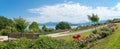 Beautiful landscape park with wooden bench, tourist resort Gstadt, lake chiemsee and alps in the back