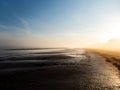 Beautiful landscape of peaceful Baltic sea beach at the sunrise in early foggy and misty morning with warm golden hour light from Royalty Free Stock Photo