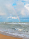 Rainbow in the cloudy sky over the sea - view from the beach Royalty Free Stock Photo