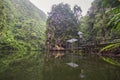 Beautiful landscape reflection of serene lake surrounded by mountains and green jungle, as an Asian woman standing by a observator Royalty Free Stock Photo