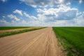 Beautiful landscape with road, green fields and cloudy sky Royalty Free Stock Photo