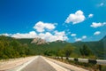 Beautiful landscape with a road in a mountainous area, sky and figured clouds Royalty Free Stock Photo