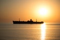 Beautiful landscape by the sea, at sunrise. The silhouette of a shipwreck. Golden colors