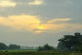 The landscape of the sun rises behind the clouds, The sun's rays through over the tree in the rice fields, Chiang Rai Royalty Free Stock Photo