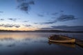 Beautiful landscape sunrise over still lake with boats on jetty Royalty Free Stock Photo