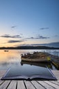 Beautiful landscape sunrise over still lake with boats on jetty Royalty Free Stock Photo