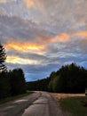 Asphalt road running along the edge of the coniferous forest through the valley to meet the mountain ranges Royalty Free Stock Photo