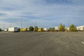 Beautiful landscape view of DHL logistic terminal. Trucks parked on huge territory on blue sky with white clouds background.