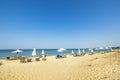 Beautiful landscape view of empty sunbeds and umbrellas on sand beach.