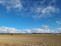 Beautiful landscape view with fields, forest trees and blue sky with white clouds. Royalty Free Stock Photo