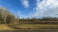 Beautiful landscape view with fields, forest trees and blue sky with white clouds. Gorgeous spring backgrounds. Royalty Free Stock Photo