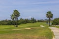 Beautiful landscape view of golf course with green grass, palm trees and lake. Royalty Free Stock Photo