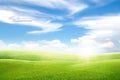 Beautiful landscape view of Green grass natural meadow field and little hill with white clouds and blue sky. Royalty Free Stock Photo