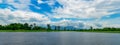 Beautiful landscape view of lake in front of the mountain with blue sky and white cumulus clouds. Green tree and grass field Royalty Free Stock Photo