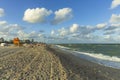 Beautiful landscape view of Miami South Beach coast line. Sand beach, Atlantic Ocean, people and high buildings on blue sky.