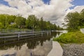 Beautiful landscape view of river with facility for passage of watercraft with green forest trees on both sides against blue sky. Royalty Free Stock Photo