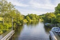 Beautiful landscape view of river with green forest trees on both sides and boats on blue sky background Royalty Free Stock Photo