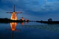 Beautiful landscape view with a row of Dutch windmills near the canal in the evening Royalty Free Stock Photo