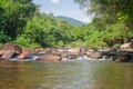 Beautiful landscape view of small waterfall in the river with water stream flowing through stone and green trees in the background Royalty Free Stock Photo