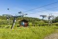 Beautiful landscape view on summer day. Cableway construction slalom ski lift on hill peak on blue sky background.