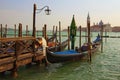 Beautiful landscape view of Venetian Lagoon. Moored gondolas near wooden pier. San Giorgio Maggiore church at the background. Royalty Free Stock Photo