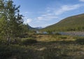 Beautiful landscape with waterfall on wild Tjaktjajakka river, birch tree forest and mountains. Lapland naturein summer at Royalty Free Stock Photo