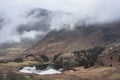 Beautiful landscape Winter sunrise of Blea Tarn from Side Pike in English Lake District with low level clouds over mountain tops Royalty Free Stock Photo