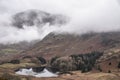 Beautiful landscape Winter sunrise of Blea Tarn from Side Pike in English Lake District with low level clouds over mountain tops Royalty Free Stock Photo