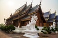 Beautiful Lanna style wooden building with white singha statues at a Buddhist temple in Thailand. Royalty Free Stock Photo