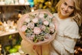 Beautiful large delicate pink bouquet of roses in the hands of blonde woman