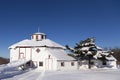 Beautiful large octogonal white barn with red trimmed windows and doors