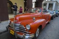 Beautiful large red classic car in busy Havana street