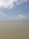 A beautiful large river of brakish water under clear blue sky  and some white cotton  clouds are floating across the sky . Royalty Free Stock Photo