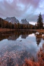 Beautiful late autumn with red colors at morning with mountain refection. Antorno lake, Italy, Europe