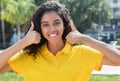 Beautiful latin american girl with long dark hair showing both thumbs Royalty Free Stock Photo