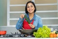 Beautiful latin american mother cooking healthy food for children