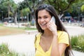 Beautiful latin american woman in yellow shirt at phone Royalty Free Stock Photo