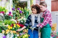 Beautiful woman buying freesias at the advice of a helpful vendo