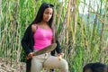 Beautiful Latin peasant girl, with a machete in her hand cutting a sugar cane