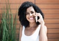 Beautiful latin woman with curly black hair at phone Royalty Free Stock Photo