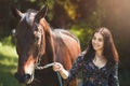 Beautiful Latin woman in dress and her lovely horse walk in the forest. love animals concept. love horses