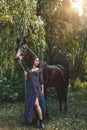 Beautiful Latin woman in dress and her lovely horse walk in the forest. love animals concept. love horses