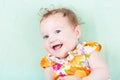 Beautiful laughing baby girl in a colorful floral dress Royalty Free Stock Photo