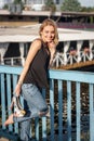 Beautiful laughing blonde standing on a bridge