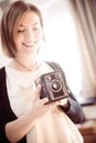 Beautiful laughing girl with a vintage film camera