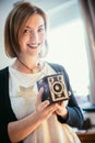 Beautiful laughing girl with a vintage film camera